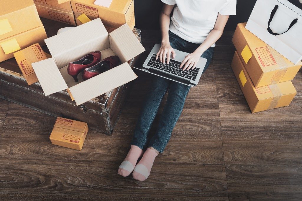 Woman surrounded by boxes shopping online