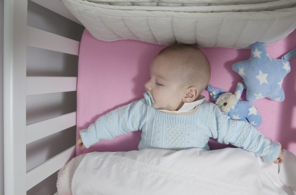 baby with pacifier sleeping in the crib