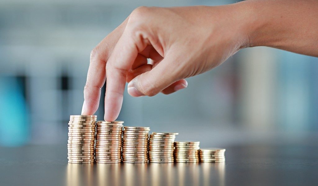 hand going up stacked coins