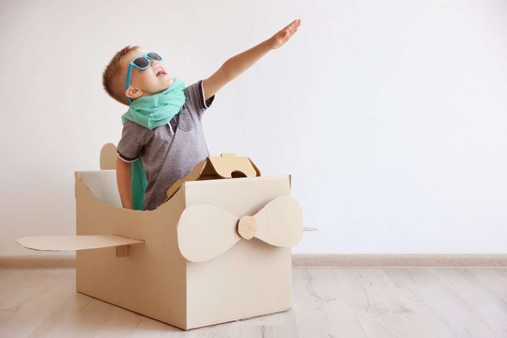 child playing on an airplane box toy